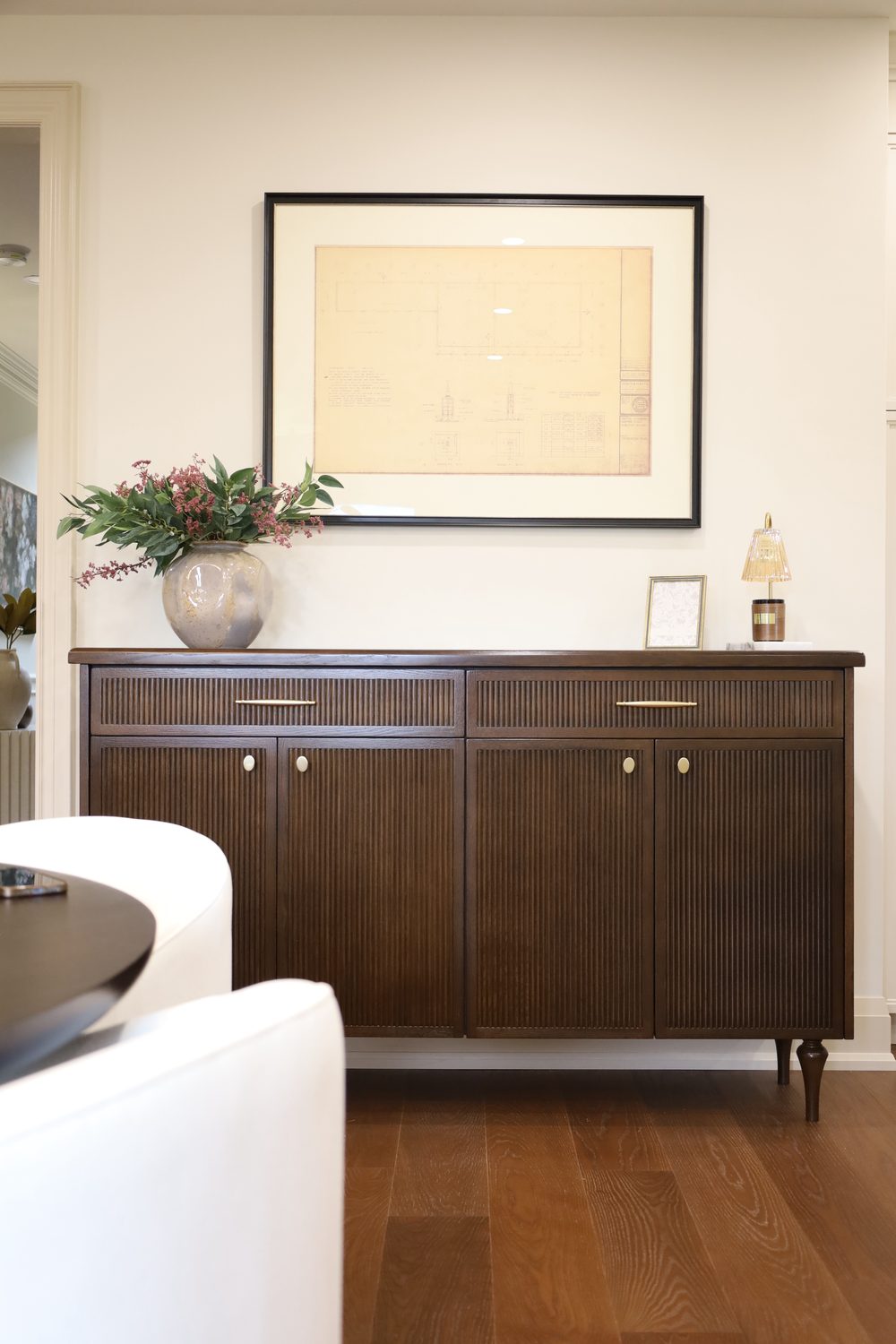 Fluted walnut sideboard with framed architectural drawing — Toronto Midtown interior design by Erica Yolevski Design Studio